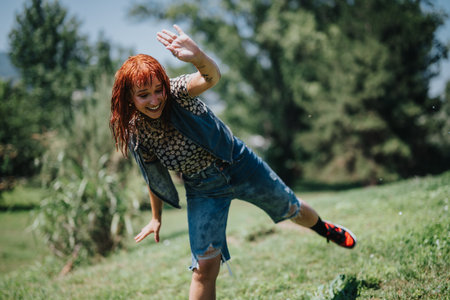 Young woman having fun at the fountain in a sunny parkの写真素材