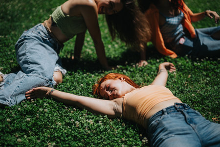 Young adults enjoying a sunny day in the park, relaxing on the grass