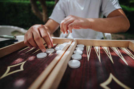 Person playing backgammon game outdoors on sunny dayの写真素材