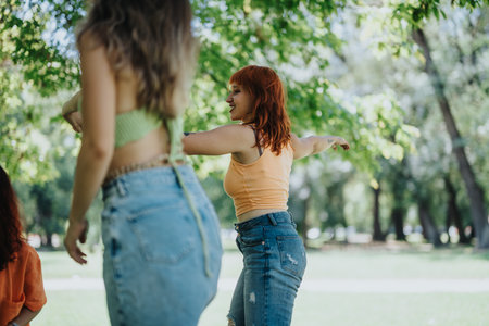 Young adults enjoying a sunny day in a park, having fun and relaxing outdoorsの写真素材