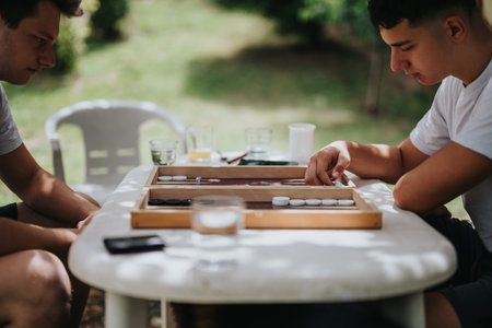 Two friends playing backgammon in a sunny garden setting
