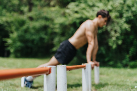 Fit man exercising in nature doing push-ups outdoors on a sunny dayの写真素材