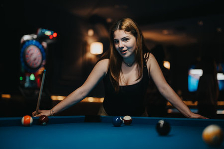 Confident young woman playing pool in a dimly lit bar