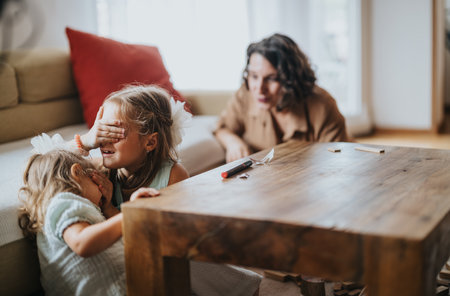 Children playing hide and seek indoors with family interactionの写真素材