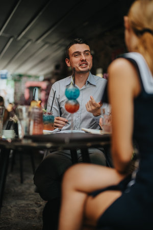 Two people discussing ideas in a casual outdoor cafe settingの写真素材