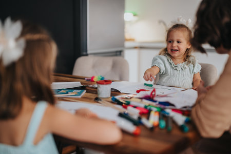 Mother and daughters enjoying creative art activities at homeの写真素材