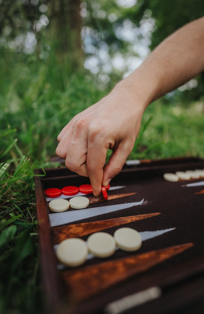 Person playing backgammon outdoors on a grassy surfaceの写真素材