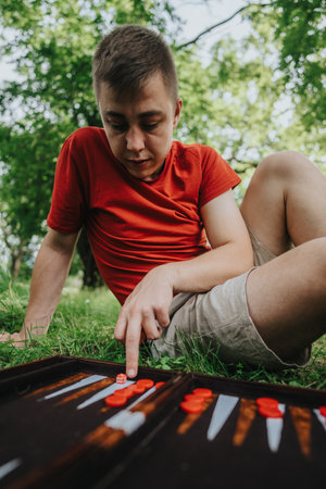 Young man playing board game outside on a sunny dayの写真素材