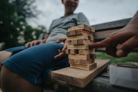 Friends enjoying a game of building blocks in an outdoor setting