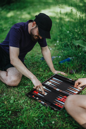 Friends playing backgammon outdoors on a sunny afternoonの写真素材