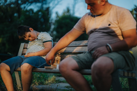 Father and son bonding while playing building blocks in the parkの写真素材