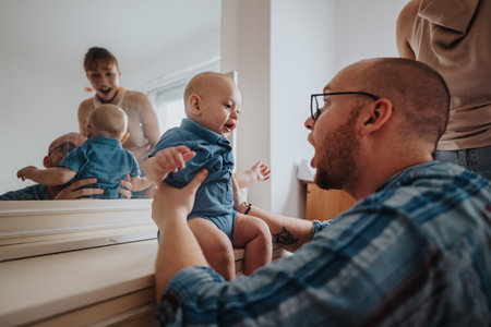 Happy family enjoying playful moments with baby in front of mirror