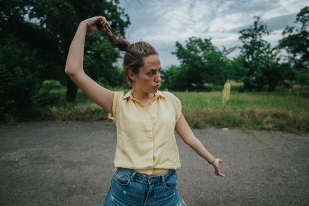 Young woman playing with her hair in an outdoor setting