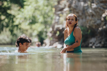 Young people enjoying a refreshing swim in a natural poolの写真素材