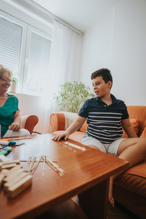 Grandmother and grandson enjoying pick up sticks game at home togetherの写真素材