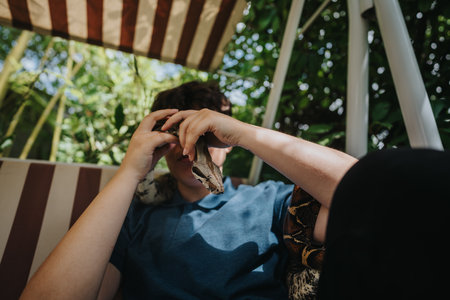 Girl enjoying a playful moment with a friendly snake outdoorsの写真素材