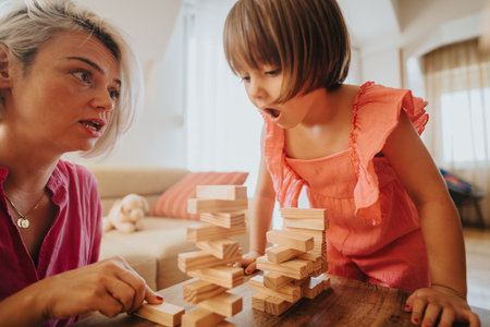 Mother and daughter playing a fun block stacking game at homeの写真素材
