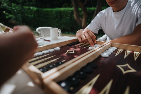 Two people playing backgammon outdoors on a sunny dayの写真素材