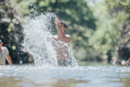Young people enjoying a refreshing splash in the summer sunの写真素材