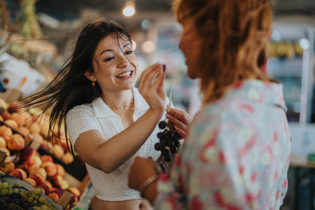 Friends enjoying fresh produce at a local farmers marketの写真素材