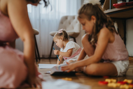 Mother and daughters enjoying creative playtime at homeの写真素材