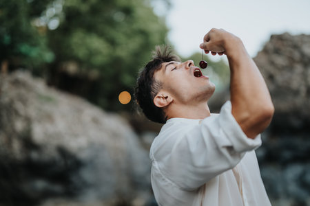 Young man enjoying fresh cherries in nature