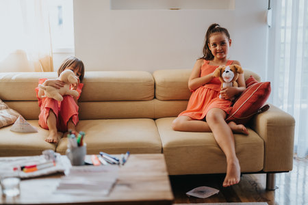 Sisters enjoying a cozy afternoon playing with stuffed animalsの写真素材