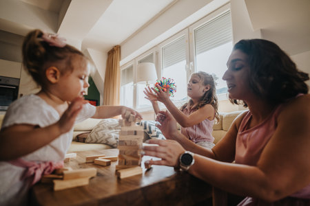 Mother playing with daughters at home, enjoying quality family time and indoor gamesの写真素材