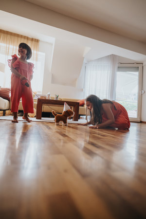 Children playing with toy dog in a sunlit living roomの写真素材