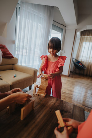 Young girl playing with wooden blocks in living roomの写真素材