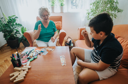 Grandmother and grandson enjoying a creative afternoon indoors togetherの写真素材
