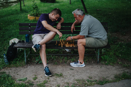 Two men playing chess on a park bench outdoors