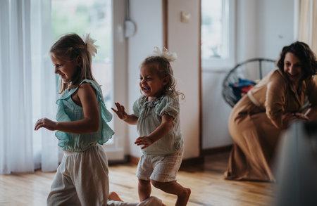 Joyful children playing indoors while mother watches happilyの写真素材