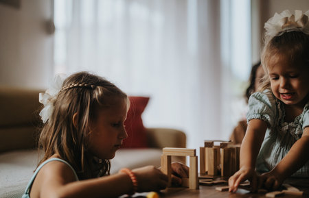 Young girls playing with wooden blocks indoors togetherの写真素材