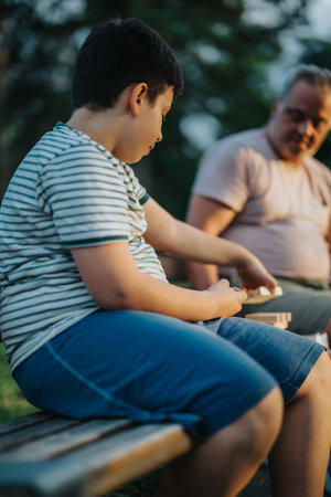 Father and son enjoying a playful block building moment in the parkの写真素材