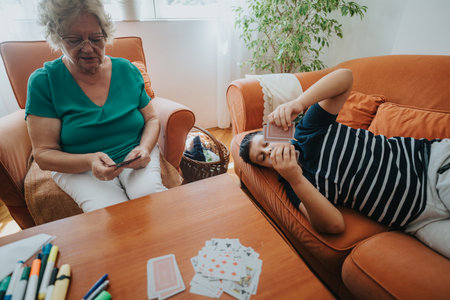 Grandmother and grandson enjoying a card game at homeの写真素材