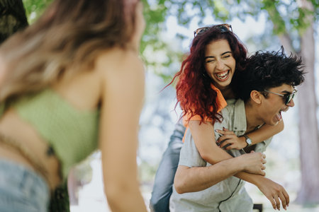 Young adults enjoying a sunny day in the park with laughter and joyの写真素材
