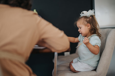 Loving mother spending quality time with her young daughter at homeの写真素材