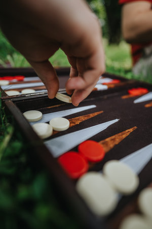 Hand placing backgammon piece outdoors on grassの写真素材
