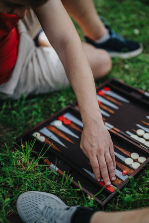 Close-up of a person playing backgammon outdoors on a sunny dayの写真素材