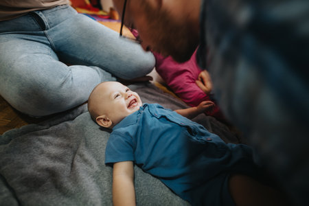 Happy baby playing on a blanket with parent at home