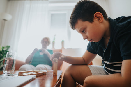 Grandmother knitting while nephew plays with building blocks at homeの写真素材
