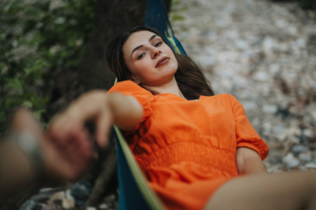 Young woman relaxing in a hammock outdoors in a serene environmentの写真素材