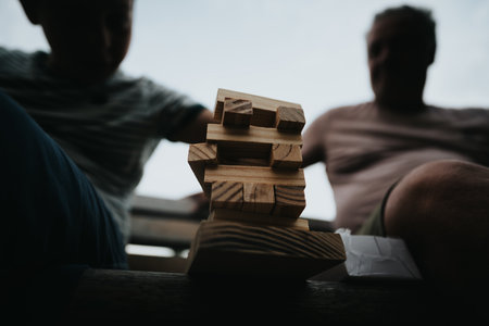Father and son playing a wooden block stacking game togetherの写真素材