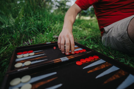 Person playing backgammon on grass in a park settingの写真素材