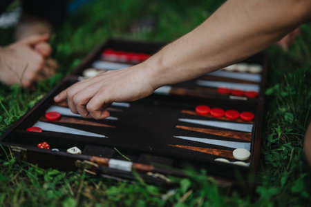 Outdoor backgammon game with friends on a grassy fieldの写真素材