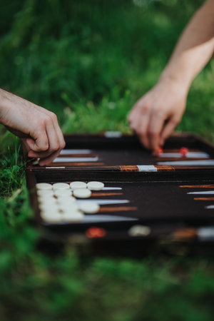 Two people playing backgammon outdoors on a sunny dayの写真素材
