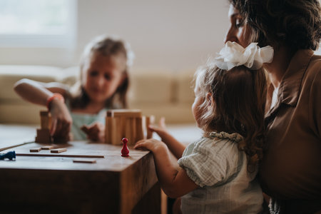 Mother playing with daughters in a cozy living room settingの写真素材