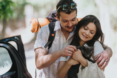 Couple enjoying a day outdoors with their pet catの写真素材