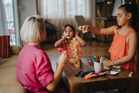Mother and daughters playing a creative game at homeの写真素材